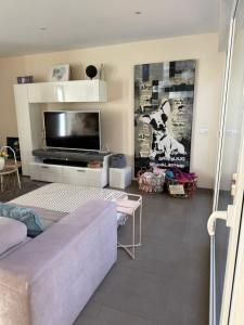 a living room with a couch and a flat screen tv at Villa Ferrera Select A in Cala Ferrera