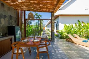 a kitchen and dining room with a table and chairs at Juna Guest House in Uluwatu