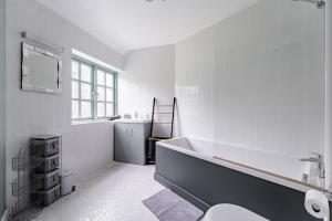 a white bathroom with a tub and a sink at 7 Bed in Coltishall oc-m31936 in Coltishall +41 photos