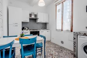 a kitchen with a table and blue chairs at Le Finestre Sul Borgo 1 in Parma +9 photos