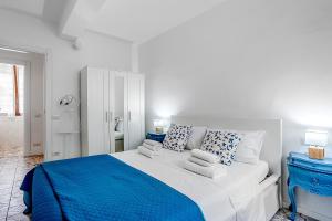 a white bedroom with a blue and white bed at Le Finestre Sul Borgo 1 in Parma