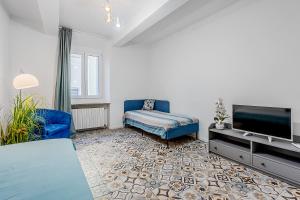 a living room with a blue couch and a flat screen tv at Le Finestre Sul Borgo 1 in Parma