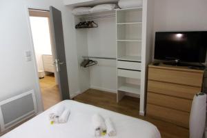 a room with a bed and a tv and a closet at Duplex House With Large Terrace And Garden in Moliets-et-Maa