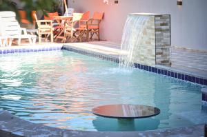 a swimming pool with a fountain in the middle at Casa Quinta MYK in Ciudad del Este