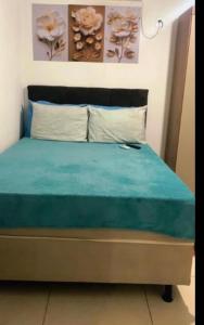 a bedroom with a bed with blue sheets and pillows at Day aconchego in Aracaju