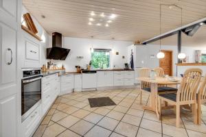 a kitchen with white cabinets and a table with chairs at C11253-Hemmet-Skuldbolvej-7-b in Hemmet