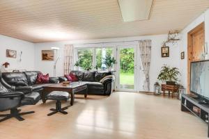 a living room with black leather furniture and a tv at C11253-Hemmet-Skuldbolvej-7-b in Hemmet