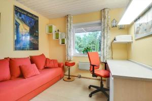 a living room with a red couch and a desk at C11253-Hemmet-Skuldbolvej-7-b in Hemmet