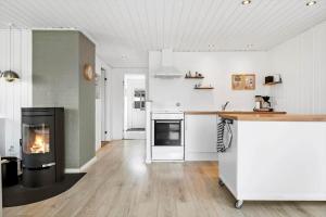 a kitchen with a stove and a fireplace at 30392-Odder-Delfinvej-5 in Odder +21 photos