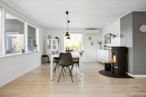 a kitchen and dining room with a table and a fireplace at 30392-Odder-Delfinvej-5 in Odder