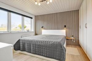 a bedroom with a bed and a large window at 30392-Odder-Delfinvej-5 in Odder