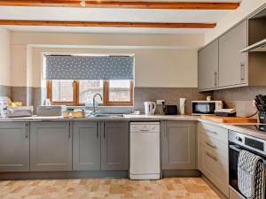 a kitchen with gray cabinets and a window with a sink at 2 Bed in Dereham oc-92392 in Whissonsett +4 photos