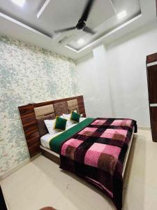 a bedroom with a bed with a colorful comforter at Hotel Lucifer by Evening Star in Bathinda
