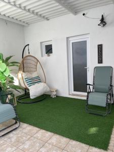 a room with two chairs and a green carpet at Catespero Sossego Villa in Reguengos de Monsaraz