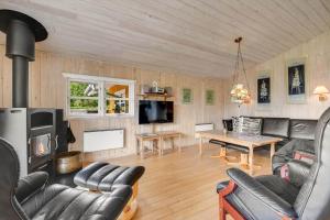 a living room with a fireplace and a table at C11645-Hemmet-Kosigvaenget-100 in Hemmet