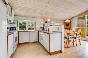 a kitchen with white appliances and a table and chairs at C11645-Hemmet-Kosigvaenget-100 in Hemmet