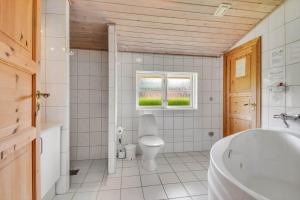 a bathroom with a toilet and a sink and a tub at C11645-Hemmet-Kosigvaenget-100 in Hemmet +28 photos