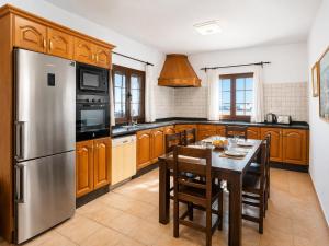 a kitchen with a table and a stainless steel refrigerator at Villa El Callao in La Asomada