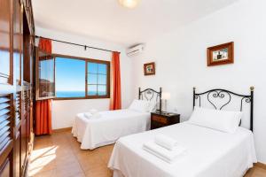 two beds in a room with a window at Villa El Callao in La Asomada +13 photos