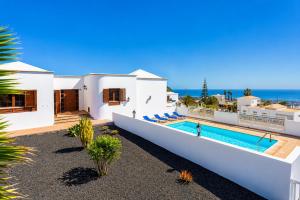 a white house with a swimming pool and the ocean at Villa El Callao in La Asomada