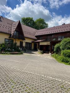 a building with a cobblestone street in front of it at Domek Koniec Świata in Dzianisz
