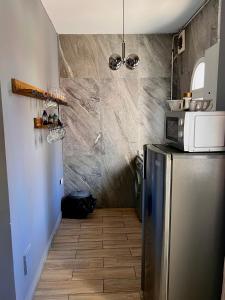 a kitchen with a refrigerator and a tile floor at la Soukra in Sukrah