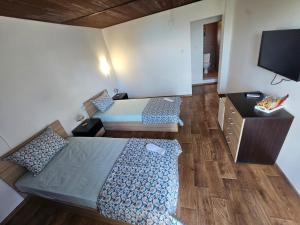 a bedroom with two beds and a flat screen tv at Къща за гости Калабрия in Golden Sands