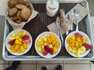 a tray with three plates of fruit on a table at EL Jardin De Los Anturios in Xico