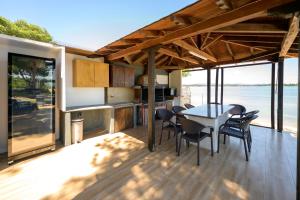 a kitchen and dining area of a house with a table and chairs at Studios Efi beach in Vourvourou