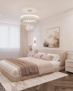 a white bedroom with a large bed and a chandelier at Lutsk Elegance Apartment in Lutsk