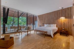 a bedroom with a large bed and a dining room at Capitalia Temistocles Polanco in Mexico City