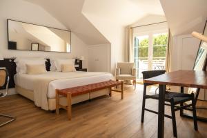 a bedroom with a bed and a table and a desk at Vila Bicuda Resort in Cascais +55 photos