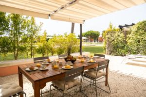 a wooden table under an umbrella on a patio at Vila Bicuda Resort in Cascais