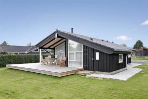 a small black house with a porch and a deck at 30078-Malling-Peter-Eriksensvej-21 in Malling