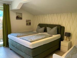 a bedroom with a bed with a green headboard at Ferienwohnung Sevim in Lermoos