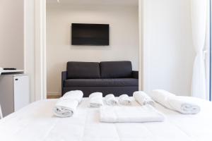 a room with a bed with towels and a couch at Palazzo Ambra in Soverato Marina