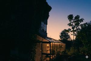 a building with a lit up window at sunset at Gladeholm in Kivik