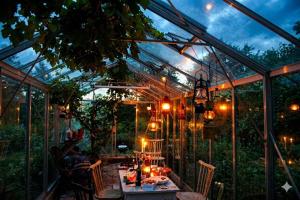 a glass house with a table and chairs in it at Gladeholm in Kivik