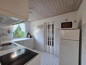 a kitchen with a white refrigerator and a sink at Inselidyll in Karlshagen +15 photos