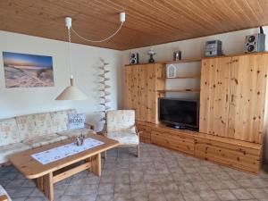 a living room with a couch and a table and a tv at Inselidyll in Karlshagen