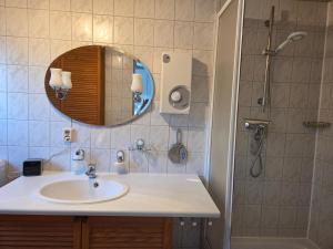 a bathroom with a sink and a shower with a mirror at Inselidyll in Karlshagen