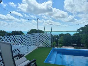 a backyard with a white fence and a swimming pool at HOKAB in Cenote Azul