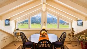 a dining room with a table and chairs and windows at Ferienwohnung Biechteler in Schwangau