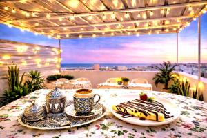 a table with plates of food and a cup of coffee at Dar Aziz VIP in Sousse