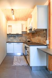 a kitchen with white cabinets and a counter top at Mansarda al Lago Casa Lavaredo in Auronzo di Cadore