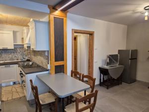 a kitchen with a table and chairs and a sink at Mansarda al Lago Casa Lavaredo in Auronzo di Cadore +11 photos