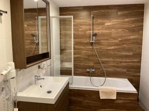 a bathroom with a tub and a sink and a shower at Ferienwohnung Sevim in Lermoos +100 photos