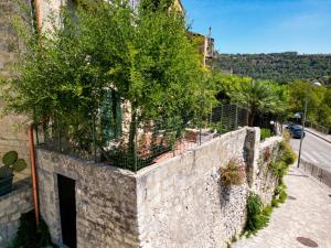 a stone wall with a tree on top of it at Lues Incanto in Ragusa +12 photos