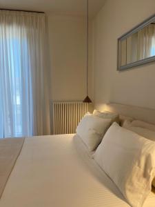 a bedroom with a large white bed with a window at Modern Apartment Empoli in Empoli