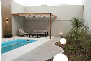 a backyard with a swimming pool and a pergola at VAYU LuxuryLofts in Bahía Blanca